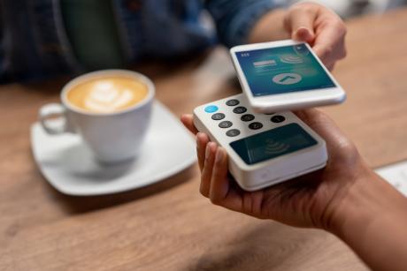 Person paying for a coffee with their mobile